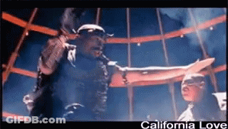 A Man Singing Into A Microphone With The Words California Love Written Below Him GIF