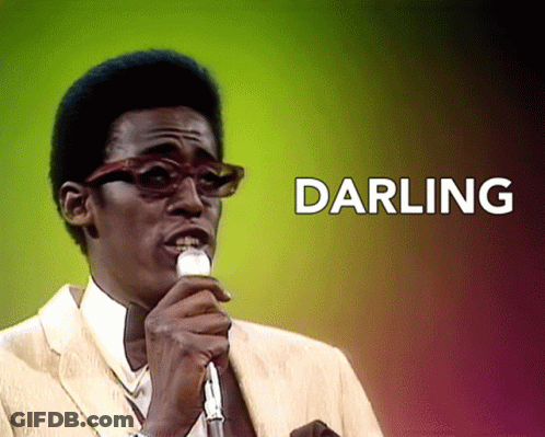 A Man Singing Into A Microphone With The Words Darling Behind Him GIF