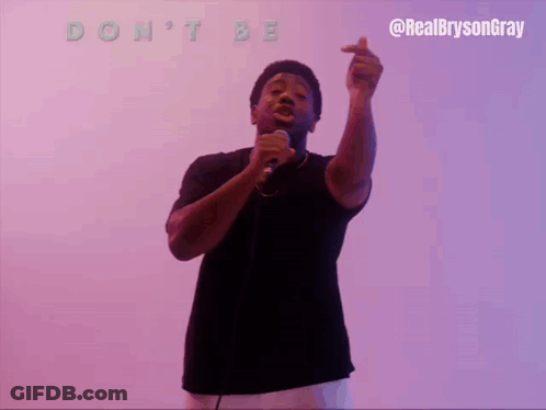 A Man Singing Into A Microphone With The Words " Do N't Be Spoiled " Above Him GIF
