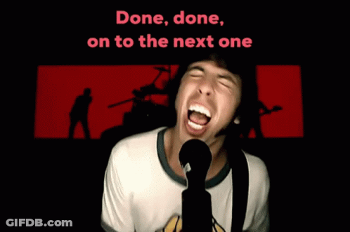 A Man Singing Into A Microphone With The Words " Done Done On To The Next One " Behind Him GIF