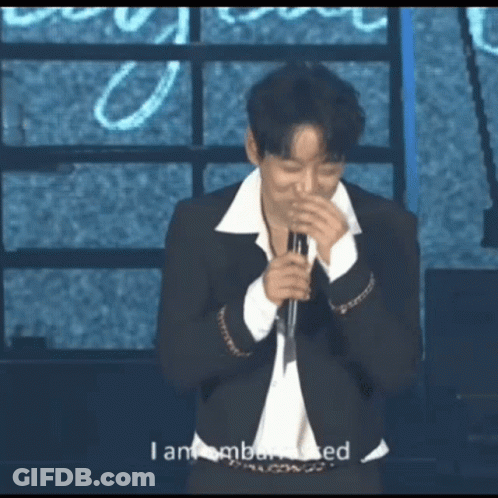 A Man Singing Into A Microphone With The Words I Am Embarrassed Behind Him GIF