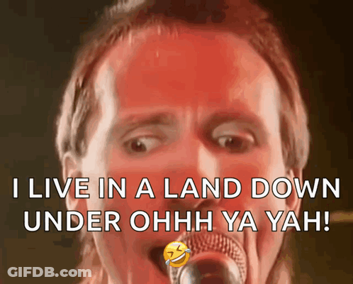 A Man Singing Into A Microphone With The Words " I Live In A Land Down Under Ohh Ya Yah " GIF