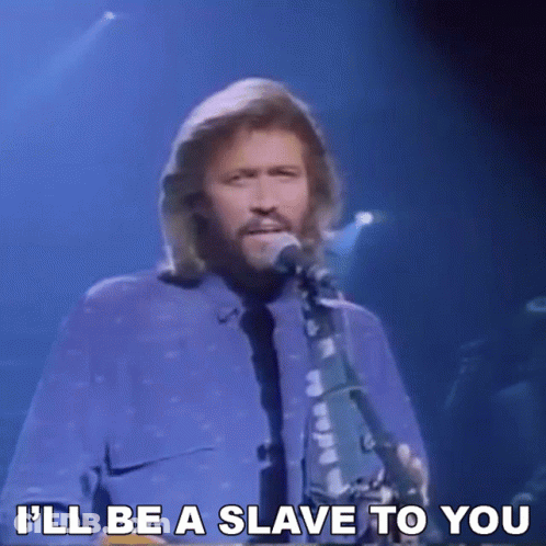 A Man Singing Into A Microphone With The Words " I 'Ll Be A Slave To You " Next To Him GIF