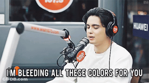 A Man Singing Into A Microphone With The Words I 'M Bleeding All These Colors For You GIF