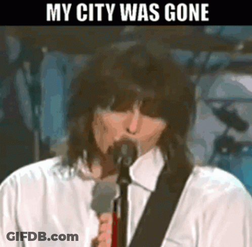 A Man Singing Into A Microphone With The Words " My City Was Gone " Above Him GIF