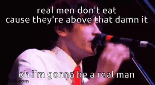 A Man Singing Into A Microphone With The Words " Real Men Don 'T Eat Cause They 'Re Above That Damn It " GIF