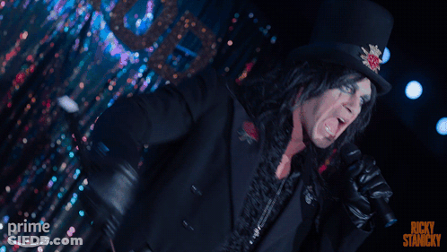A Man Singing Into A Microphone With The Words Ricky Stancky On The Bottom Right GIF