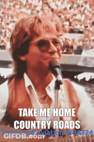 A Man Singing Into A Microphone With The Words Take Me Home Country Roads Above Him GIF