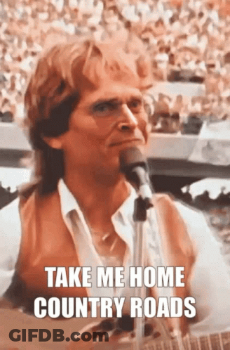 A Man Singing Into A Microphone With The Words Take Me Home Country Roads Above Him GIF