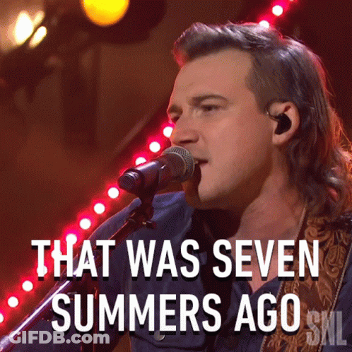 A Man Singing Into A Microphone With The Words That Was Seven Summers Ago Below Him GIF