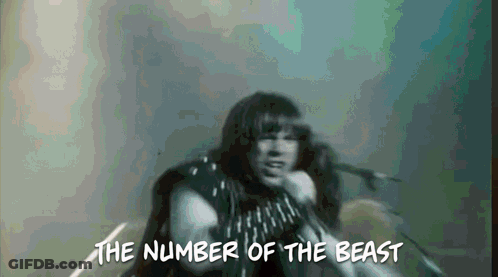 A Man Singing Into A Microphone With The Words " The Number Of The Beast " Above Him GIF