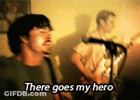 A Man Singing Into A Microphone With The Words " There Goes My Hero " GIF