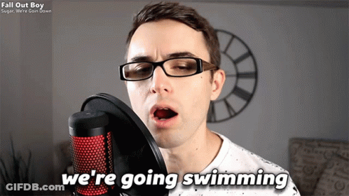 A Man Singing Into A Microphone With The Words " We 'Re Going Swimming " Next To Him GIF