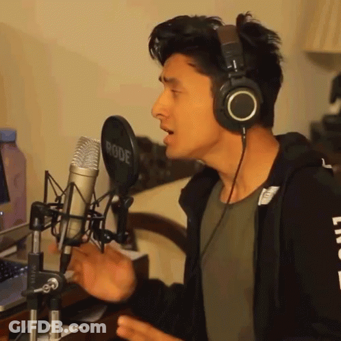A Man Singing Into A Rode Microphone With Headphones On GIF