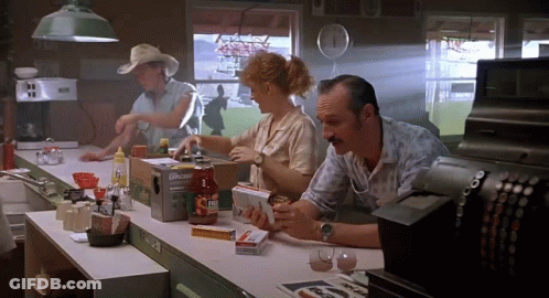A Man Sits At A Counter In A Diner With A Box Of Upside Down Ketchup GIF