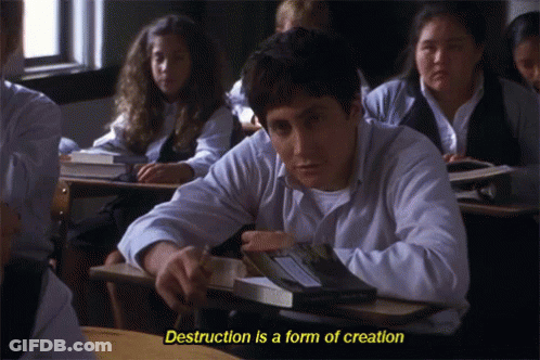 A Man Sits At A Desk In A Classroom With The Words " Destruction Is A Form Of Creation " Above Him GIF