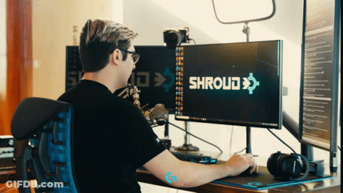 A Man Sits At A Desk With A Computer Monitor That Says Shroud On It GIF