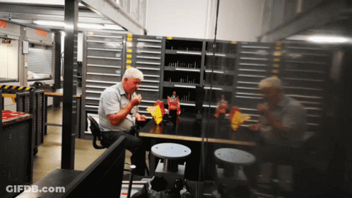 A Man Sits At A Table Eating Chips And Drinking A Coca Cola GIF