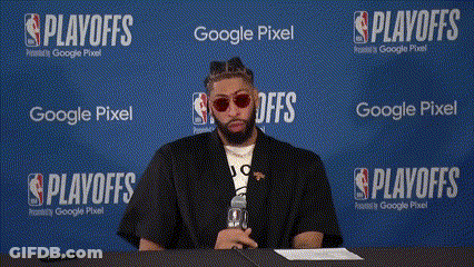 A Man Sits At A Table In Front Of A Wall That Says Playoffs GIF