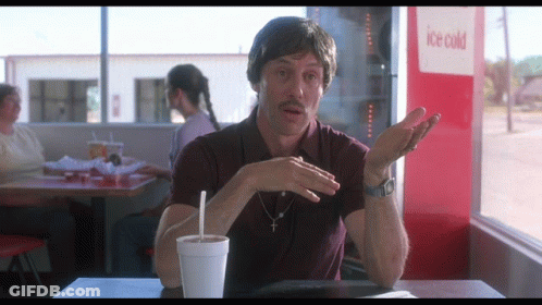 A Man Sits At A Table In Front Of An Ice Cold Drink Machine GIF