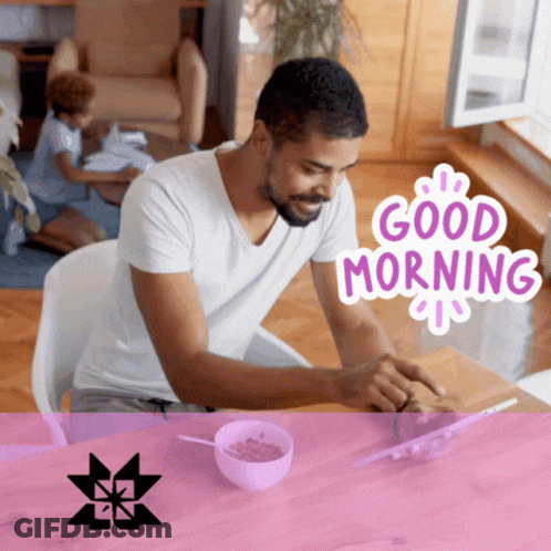 A Man Sits At A Table With A Bowl Of Cereal And A Good Morning Sticker On The Bottom GIF
