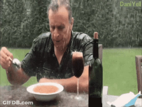 A Man Sits At A Table With A Bowl Of Soup And A Glass Of Wine GIF
