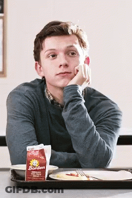 A Man Sits At A Table With A Carton Of Borden Milk On It GIF