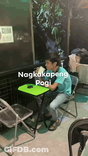 A Man Sits At A Table With A Sign That Says Clean As You Go Behind Him GIF