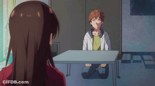 A Man Sits At A Table With A Woman Looking At Him GIF