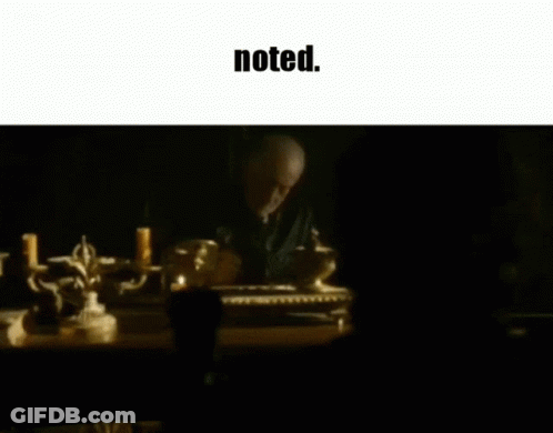 A Man Sits At A Table With Candles And The Words Noted Below Him GIF