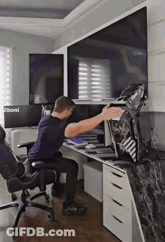 A Man Sits In A Chair In Front Of A Computer Monitor With The Words 2Boni On The Bottom Left GIF