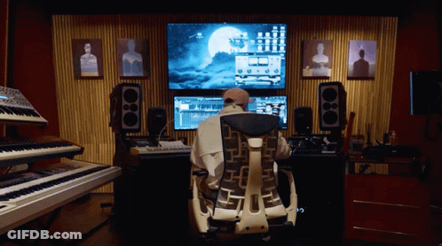 A Man Sits In A Chair In Front Of A Computer Screen With A Full Moon On It GIF