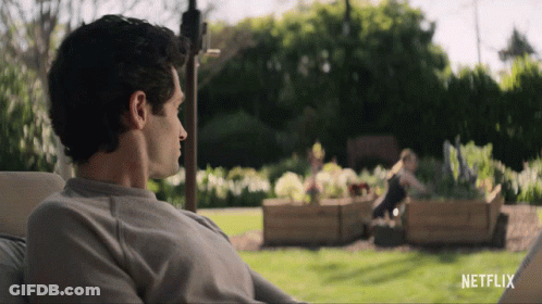 A Man Sits In A Chair In Front Of A Netflix Sign GIF