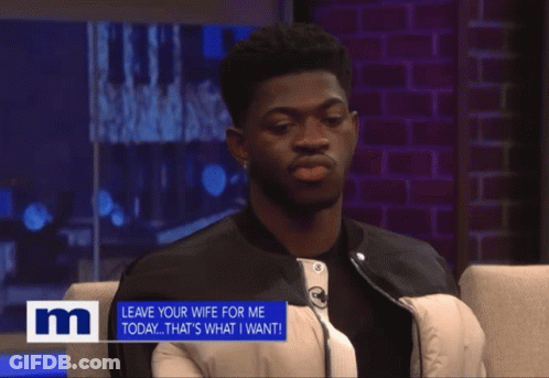 A Man Sits In A Chair With A Sign That Says " Leave Your Wife For Me Today " GIF