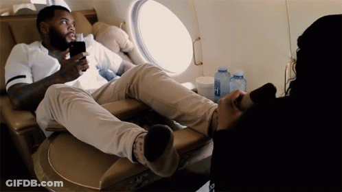 A Man Sits In A Chair With His Feet Up And A Bottle Of Aquafina Water In Front Of Him GIF