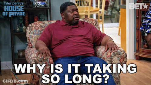 A Man Sits In A Chair With The Words " Why Is It Taking So Long " Above Him GIF