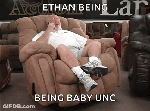 A Man Sits In A Recliner With The Words " Ethan Being Being Baby Unc " Written Below Him GIF