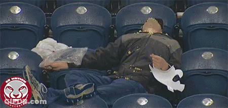 A Man Sits In A Stadium With The Word Cougcenter On The Bottom Left GIF
