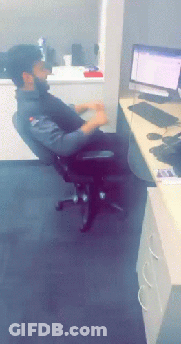A Man Sits In An Office Chair In Front Of A Computer Screen GIF