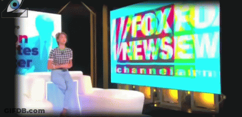 A Man Sits In Front Of A Fox News Screen GIF