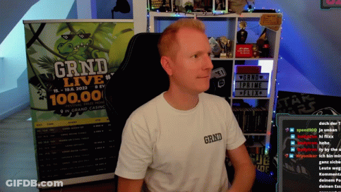 A Man Sits In Front Of A Grind Live Sign GIF