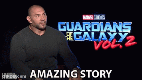 A Man Sits In Front Of A Guardians Of The Galaxy Vol 2 Sign GIF