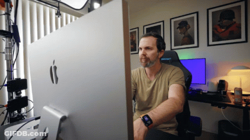 A Man Sits In Front Of A Large Apple Monitor GIF