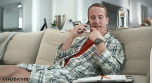 A Man Sits On A Couch Talking On A Cell Phone GIF