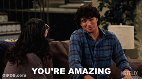 A Man Sits On A Couch With A Woman And Says You 'Re Amazing On The Screen GIF