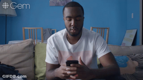 A Man Sits On A Couch With His Eyes Closed And A Gem Logo Behind Him GIF