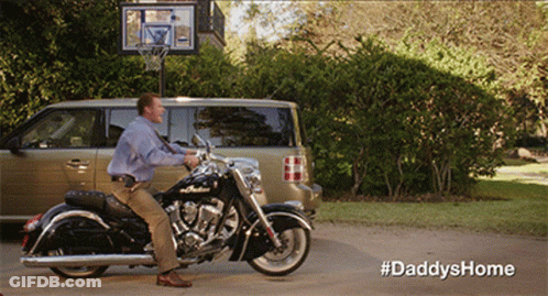 A Man Sits On A Motorcycle In Front Of A Van And A Basketball Hoop With The Hashtag #Daddyshome GIF