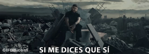 A Man Sits On A Pile Of Rubble With The Words Si Me Dices Que Si Written Below Him GIF