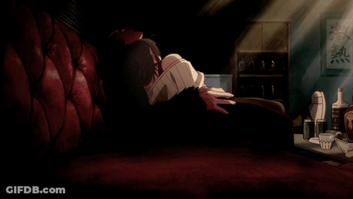 A Man Sits On A Red Couch In A Dark Room With Chinese Writing On The Wall Above Him GIF