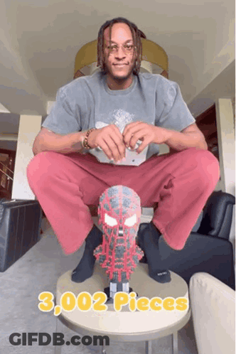 A Man Sits On A Table With A Spider Man Mask On It And Says 3,000 Pieces GIF